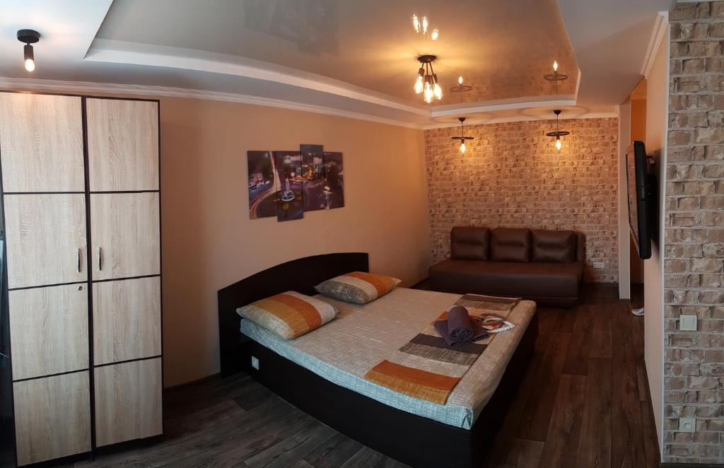 um quarto com uma cama e um sofá em Apartment new 95 Kvartal em Kryvyi Rih