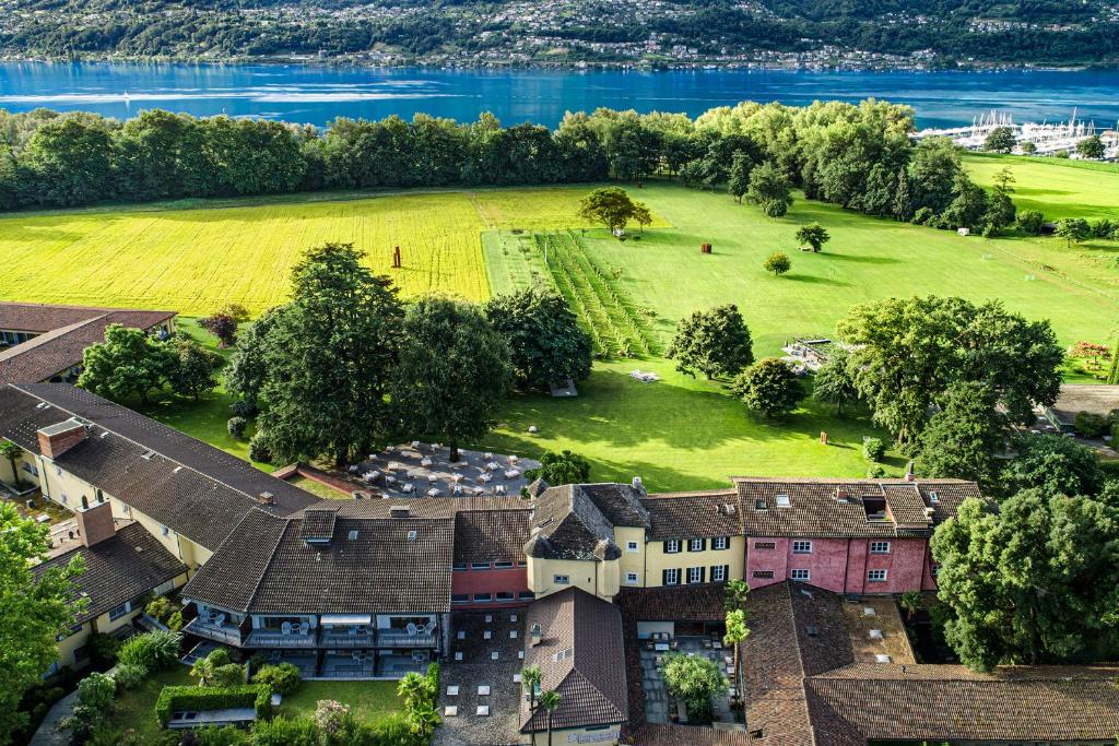 una vista aérea de una casa con un campo y agua en Castello del Sole Beach Resort&SPA, en Ascona