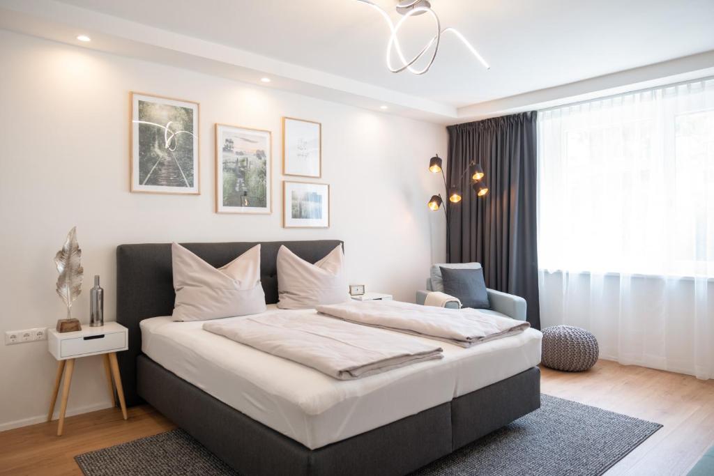 ein Schlafzimmer mit einem großen Bett und einem Stuhl in der Unterkunft MH Living - 5 - Scandinavian Living Dream in Center in Graz