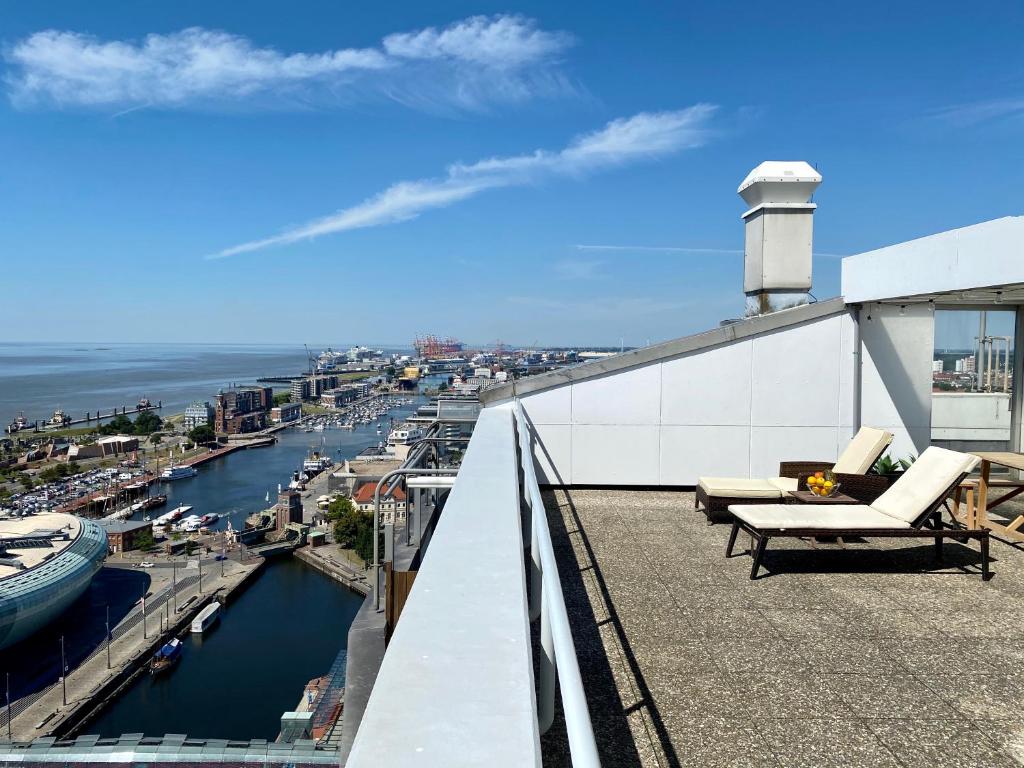 balcone con sedie e vista sul porto di COAST HOUSE Sky Suite a Bremerhaven