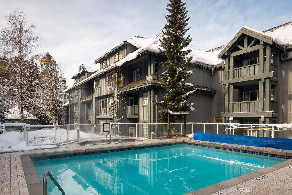 une maison avec une piscine dans la neige dans l'établissement Glacier Lodge, à Whistler