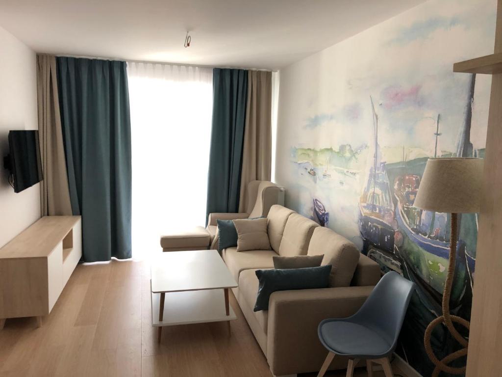 ein Wohnzimmer mit einem Sofa und einem Tisch in der Unterkunft Nadmorskie Tarasy Apartament 312 in Kołobrzeg