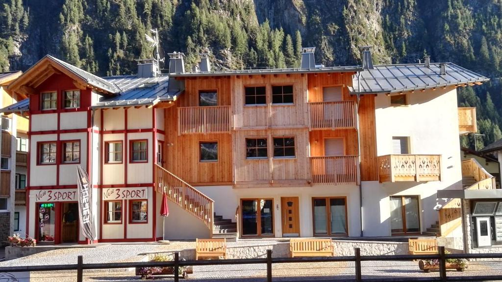 um hotel nas montanhas com um edifício em Cèsa Baissa em Campitello di Fassa