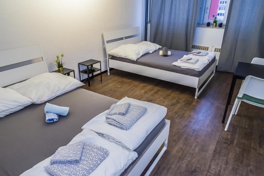 a room with two beds and a table in it at FeWo Köln in Cologne