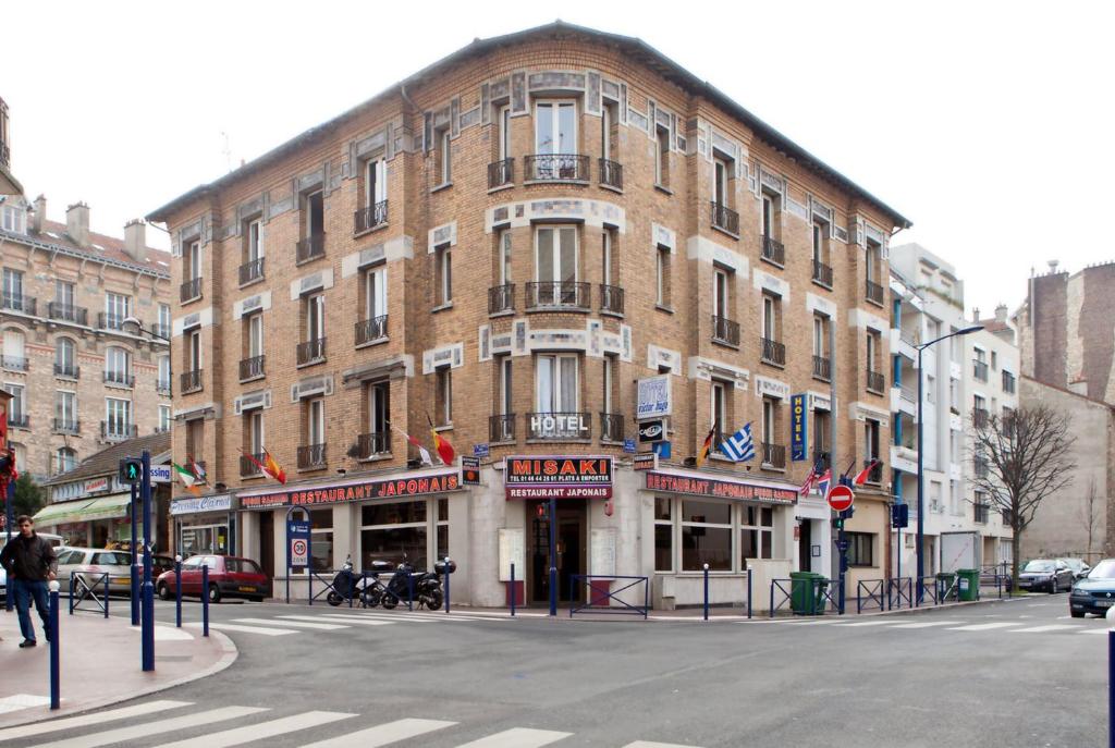 ein großes Backsteingebäude an der Ecke einer Straße in der Unterkunft Hotel Victor Hugo in Clamart