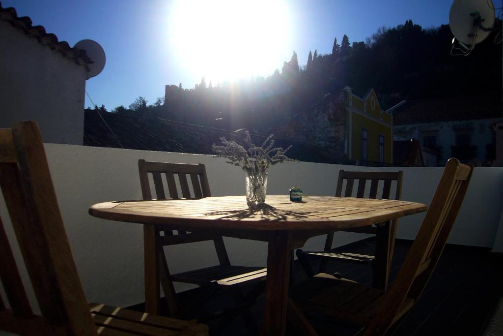 a wooden table with a vase of flowers on it at Castle, Terrace and Relax in Tomar