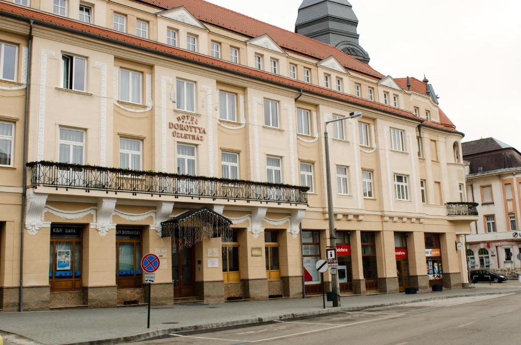 Un grand bâtiment avec balcon se trouve dans une rue. dans l'établissement Hotel Dorottya, à Kaposvár