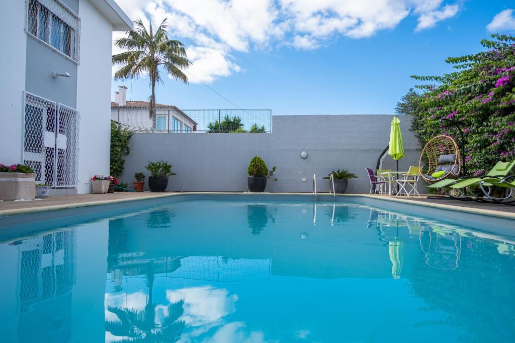 una piscina con acqua blu di fronte a un edificio di Snooker House a Ponta Delgada