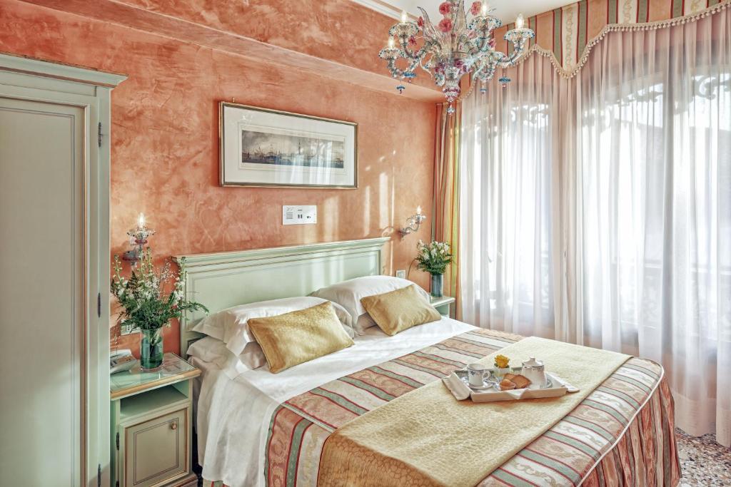 - une chambre avec un lit et un plateau de nourriture dans l'établissement Hotel Firenze, à Venise