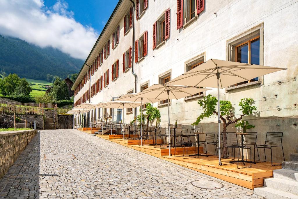 una fila di tavoli e ombrelloni accanto a un edificio di Culinarium Alpinum a Stans