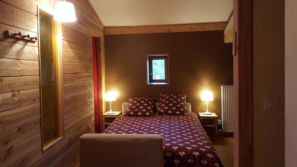 ein Schlafzimmer mit einem Bett und zwei Lampen an zwei Tischen in der Unterkunft Le Chalet du Parc in Annonay