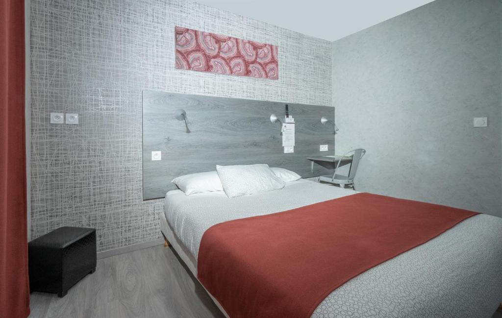 um quarto com uma cama grande e um cobertor vermelho em Hôtel Mac Bed em Poitiers