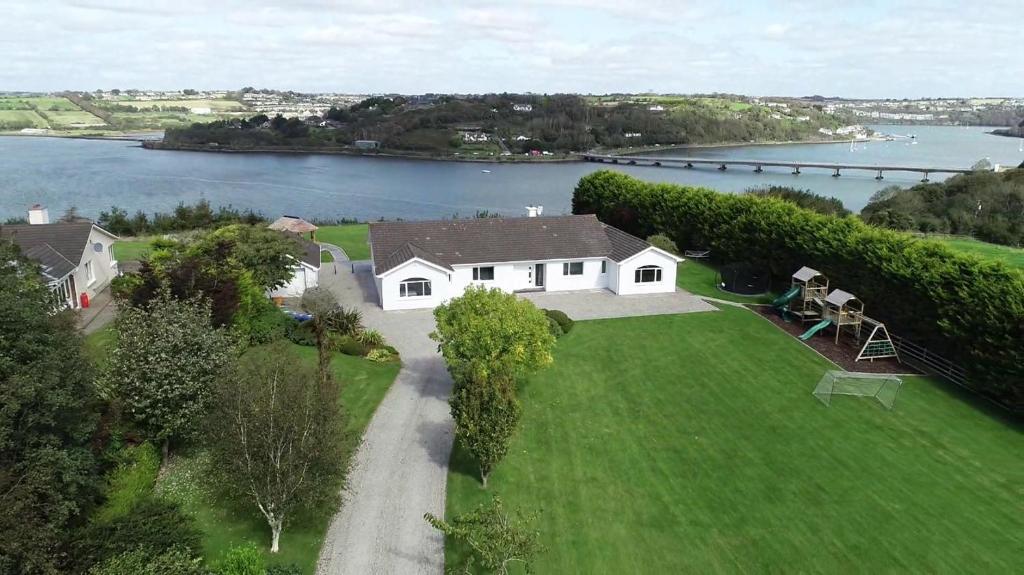 une vue aérienne sur une maison blanche sur une pelouse à côté d'un lac dans l'établissement Marina views, Kinsale, Exquisite holiday homes, sleeps 20, à Kinsale