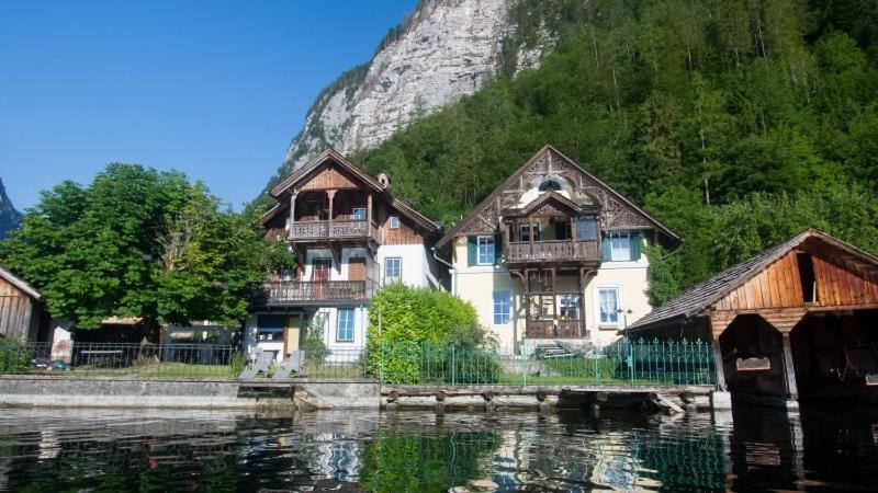 un groupe de maisons à côté d'une masse d'eau dans l'établissement Ferienwohnung KraftTanken, à Hallstatt