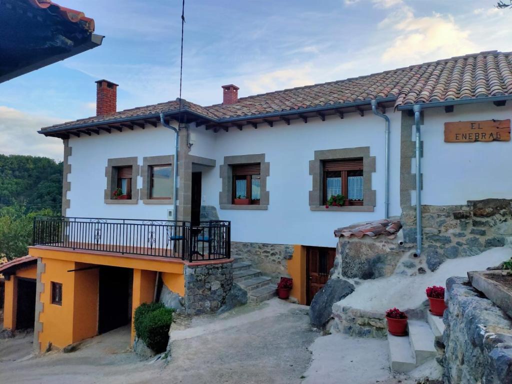 Cette maison blanche dispose d'un balcon. dans l'établissement Casa Rural el Enebral en Potes Picos de Euopa, à Colio