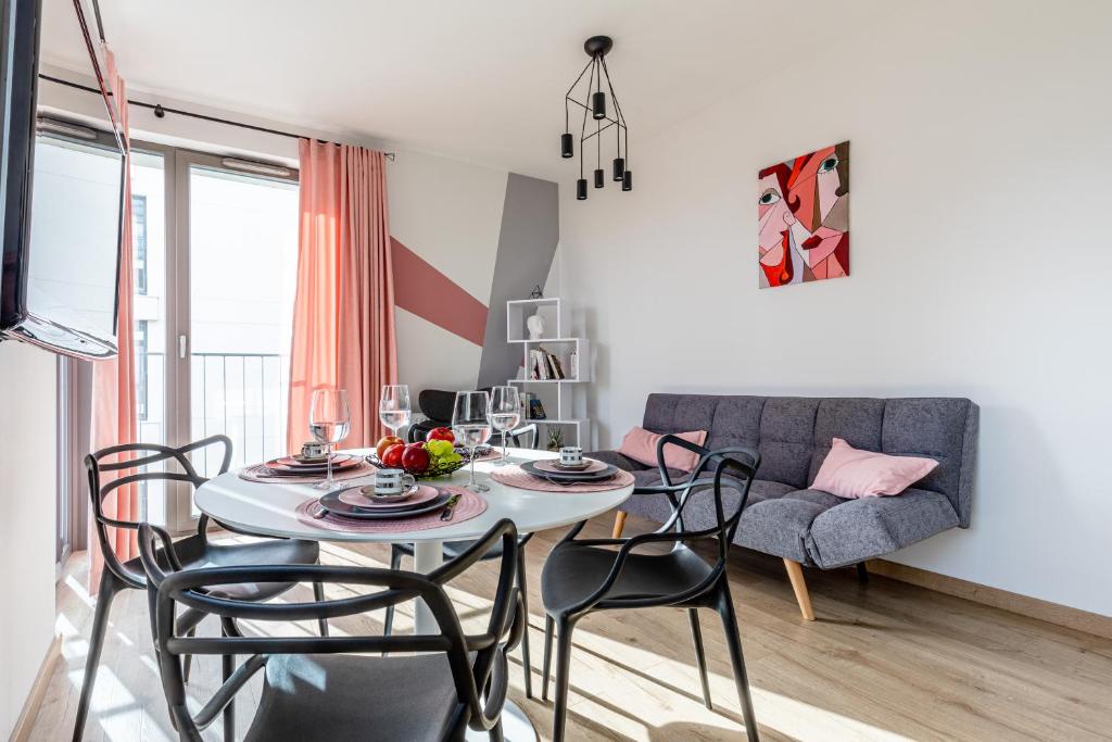 een woonkamer met een tafel en stoelen en een bank bij Apartament Old Town Nest in Gdańsk