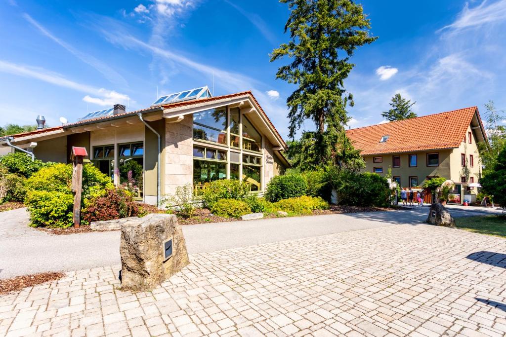 ein Gebäude mit einer Steinbank davor in der Unterkunft Forsthaus Thiemsburg im Nationalpark Hainich in Schönstedt