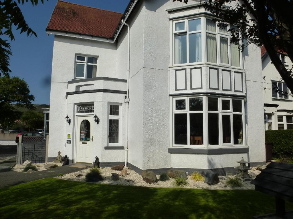 een wit huis met een groot raam bij The Kenmore Guest House in Llandudno