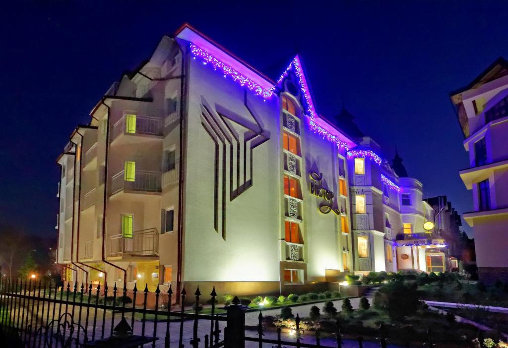 un edificio con luces moradas en él por la noche en VICTOR Hotel Resort & SPA, en Truskavets