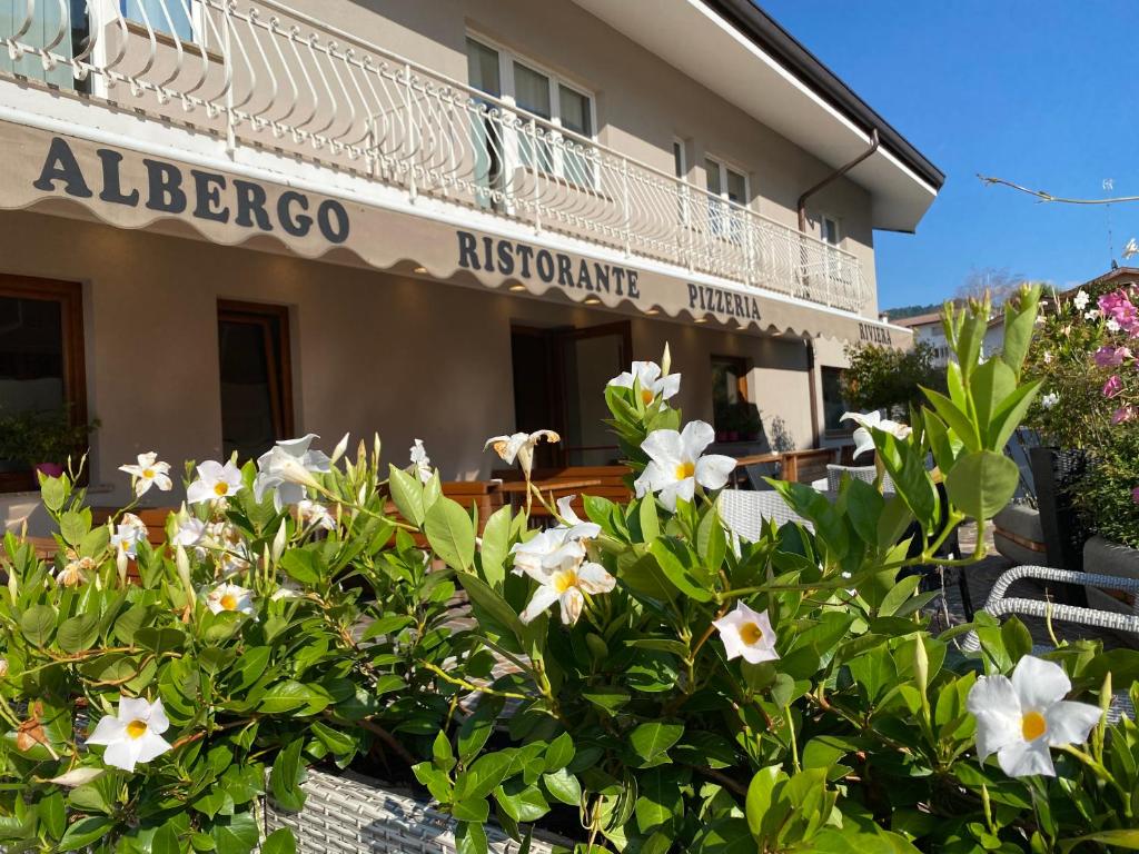 een gebouw met een bos bloemen ervoor bij Hotel Riviera in Magnano in Riviera