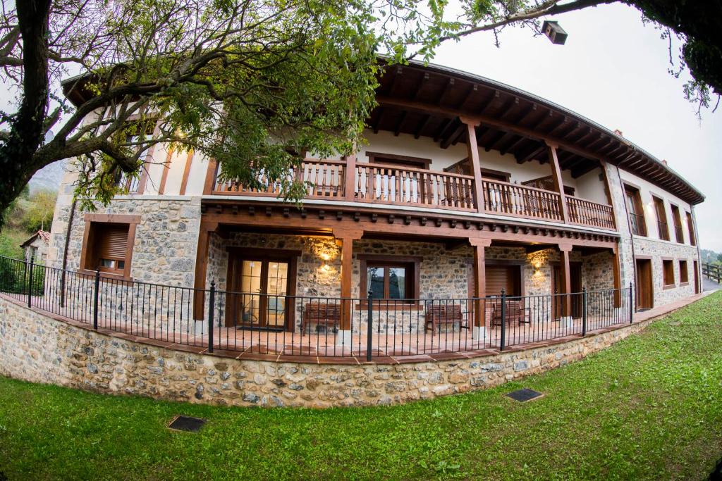 ein großes Gebäude mit Balkon auf einem Hof in der Unterkunft Apartamentos Los Picos de Europa in Colio