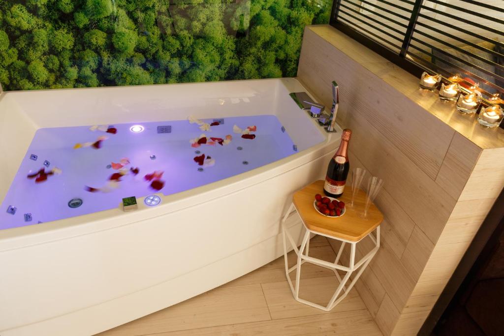 bañera con botella de champán y mesa pequeña en Luxury apartments «Love Story», en Ivano-Frankivsk