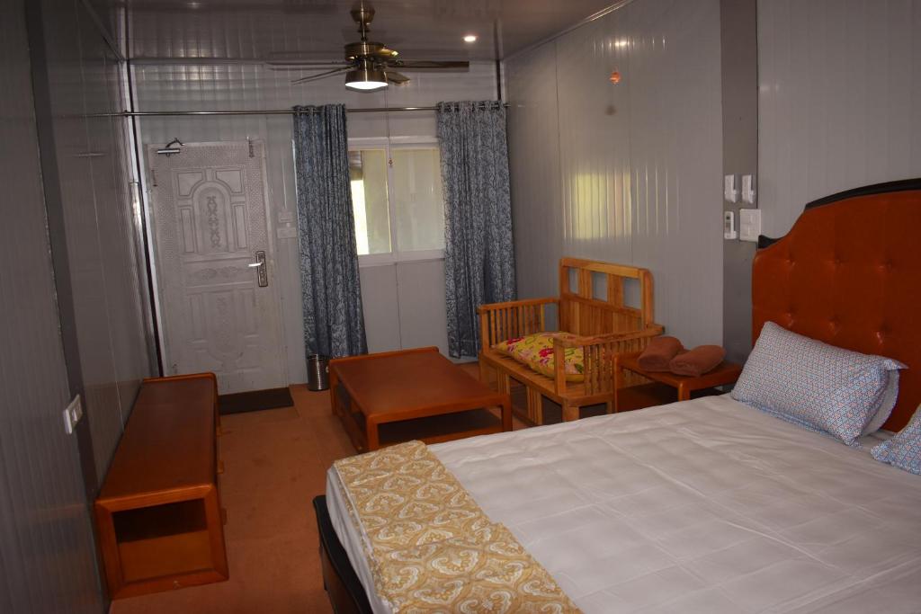 een slaapkamer met een bed en stoelen en een deur bij Private Rooms with International Airport View in New Delhi