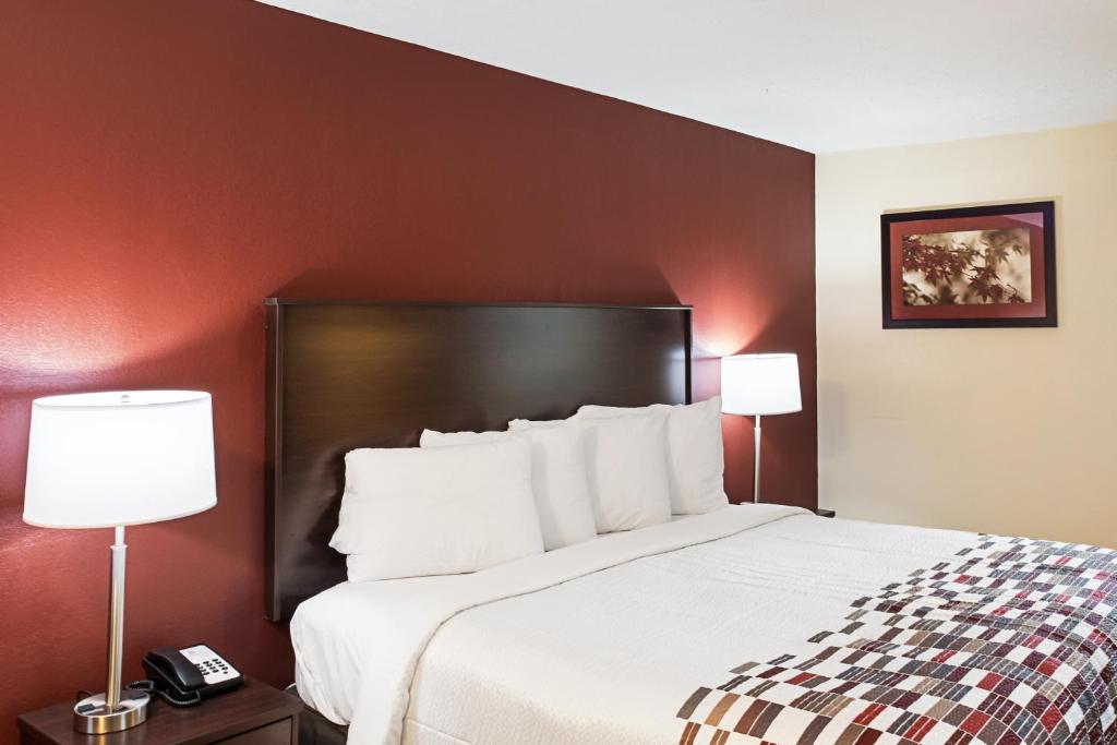 pokój hotelowy z dużym łóżkiem z 2 lampami w obiekcie Red Roof Inn Indianapolis East w mieście Indianapolis