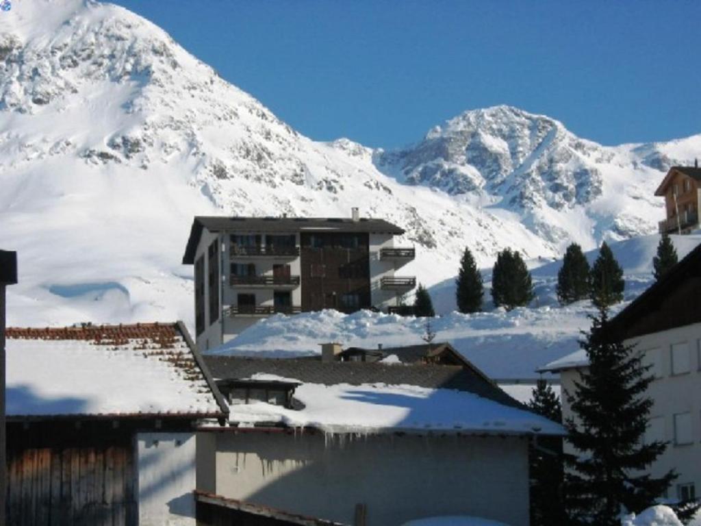 einen schneebedeckten Berg vor einem Gebäude in der Unterkunft Curtinfess Rezzonico in Bivio