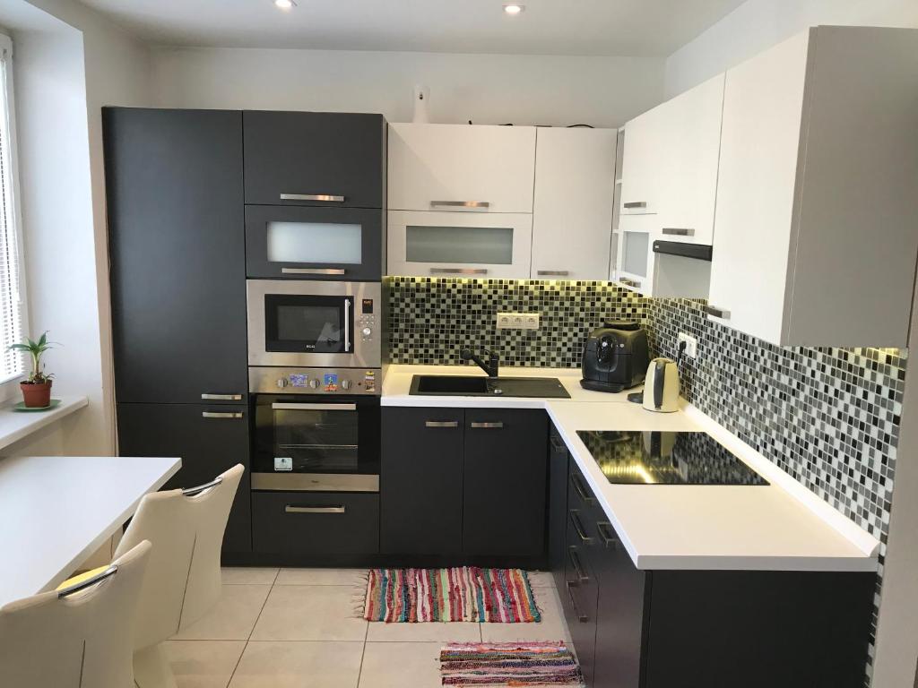 a kitchen with black and white cabinets and appliances at Apartmán v úplnom centre in Vranov nad Topľou