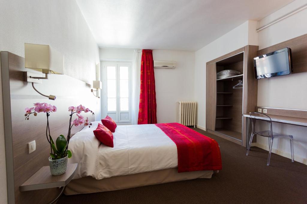 Habitación de hotel con cama con cortina roja en Hôtel de l'Europe Grenoble hyper-centre, en Grenoble