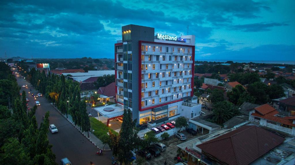 ein hohes Gebäude mit einem Hotelschild darüber in der Unterkunft Metland Hotel Cirebon by Horison in Cirebon