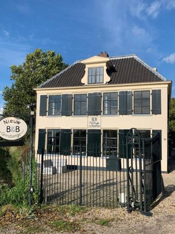 a white house with a fence in front of it at The Riverside Logies & Restaurant in Maarssen