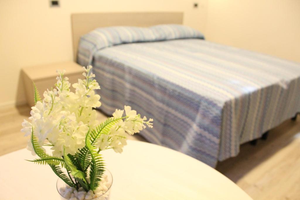 um quarto com uma cama e uma mesa com flores em Hotel la locanda di montecatone em Imola