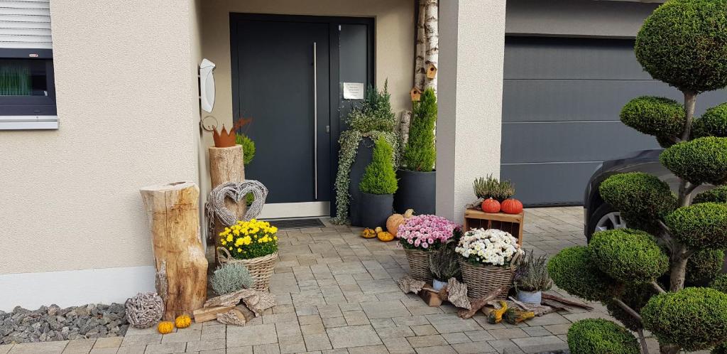 a porch with a bunch of plants and flowers in baskets at Gästehaus Ferienwohnung Abendstern in Rust