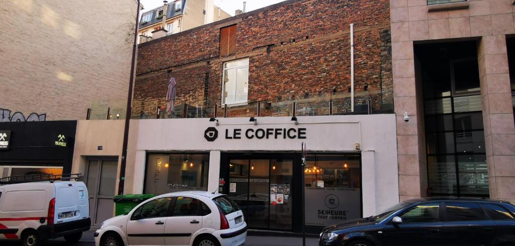 two cars parked in front of a store at Le Coffice Auberge de Jeunesse in Paris