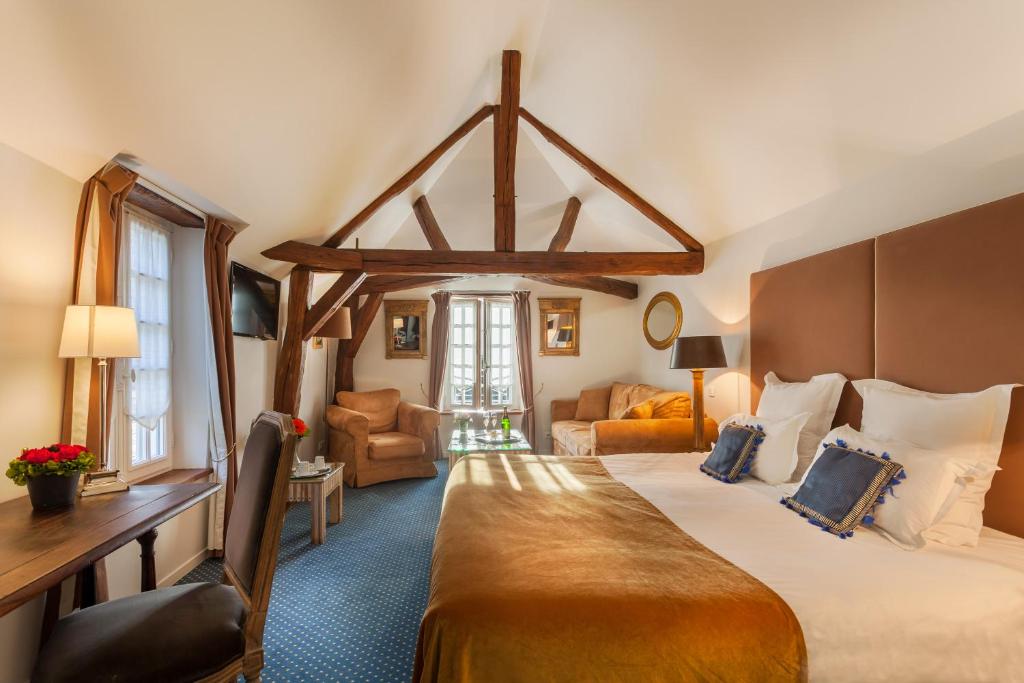 Habitación de hotel con cama grande y sala de estar. en Le Clos d'Amboise, en Amboise