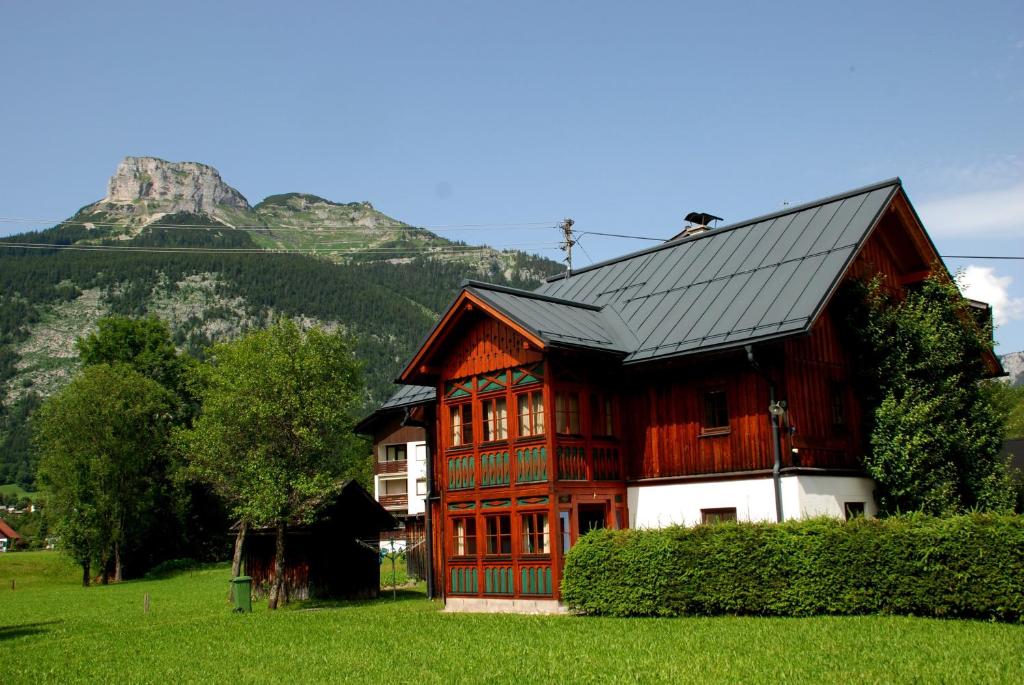 een houten huis met een berg op de achtergrond bij Haus Moser in Altaussee