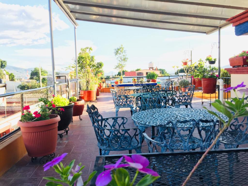 eine Terrasse mit Tischen und Stühlen auf dem Balkon in der Unterkunft Hotel Cazomalli Oaxaca in Oaxaca de Juárez