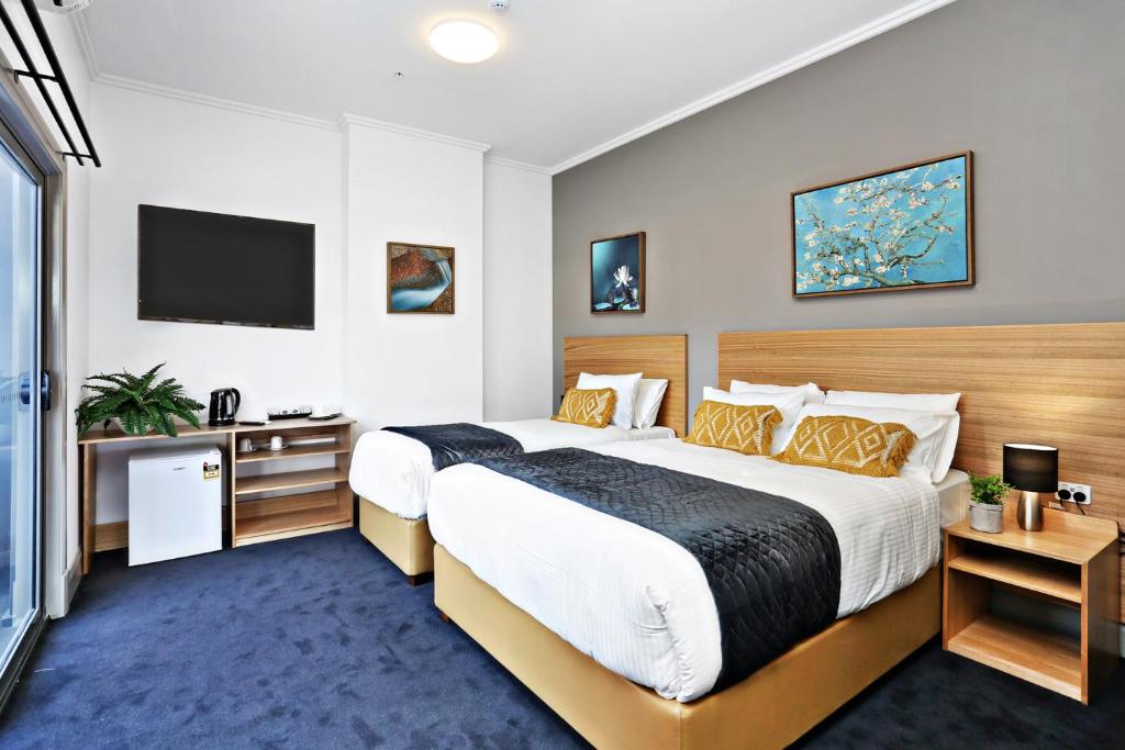 A bed or beds in a room at Meridian Hotel Hurstville