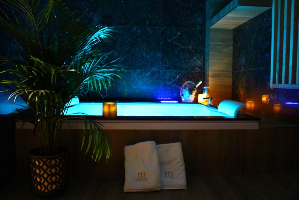 a bathroom with a tub with a potted plant and towels at Weranda Apartments in Morzyczyn