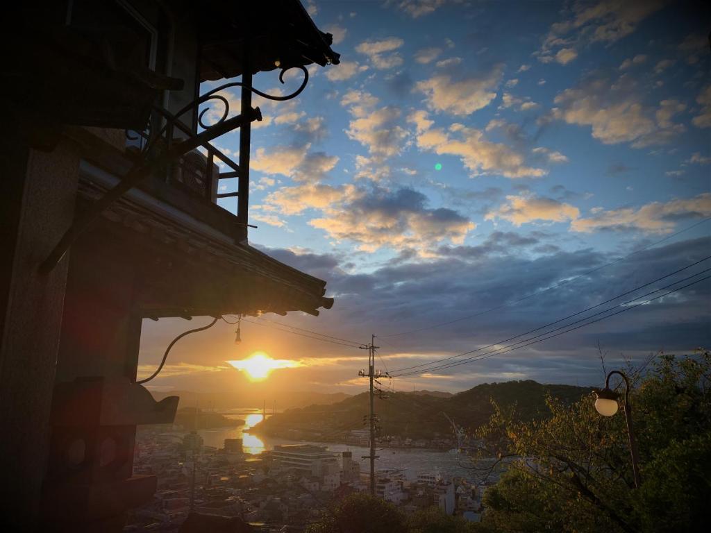 - une vue sur le coucher de soleil d'une ville dans l'établissement Onomichi Guest House Miharashi-tei, à Onomichi