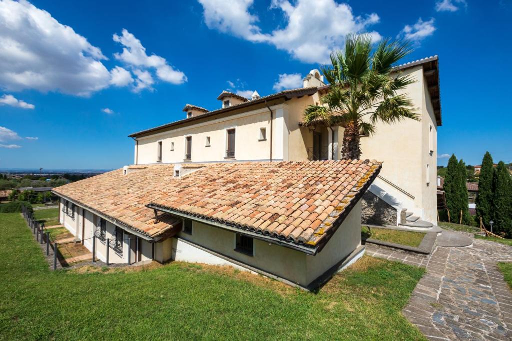 an exterior view of a house with a palm tree at Residenza d'Epoca Pietra Di Ponente in Ciampino