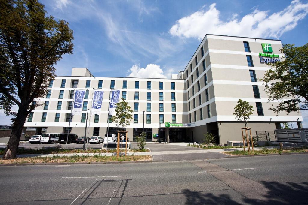 - un grand bâtiment blanc avec un panneau dans l'établissement Holiday Inn Express - Darmstadt, an IHG Hotel, à Darmstadt