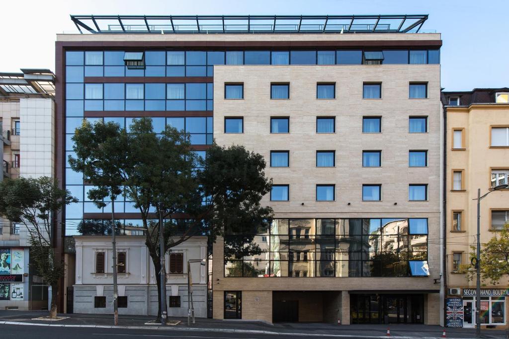 ein hohes Gebäude mit Fenstern auf einer Stadtstraße in der Unterkunft Central Point Hotel Beograd in Belgrad