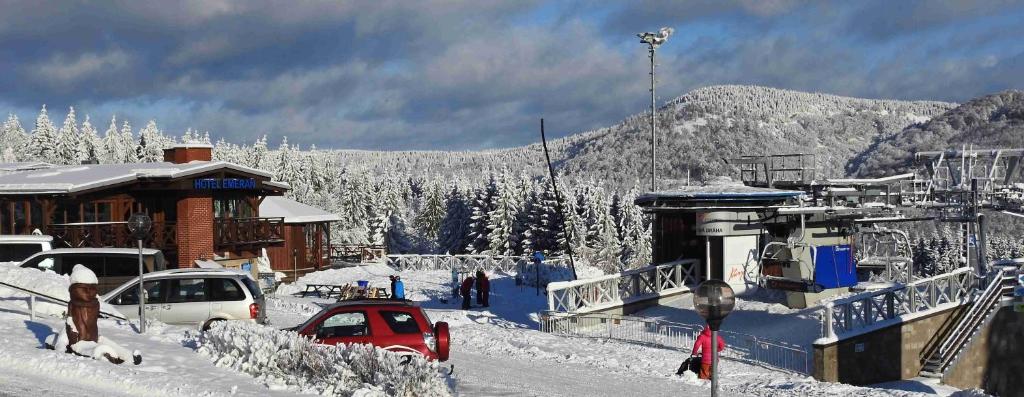 ein schneebedecktes Dorf mit Autos im Schnee in der Unterkunft Hotel Emeran in Litvínov