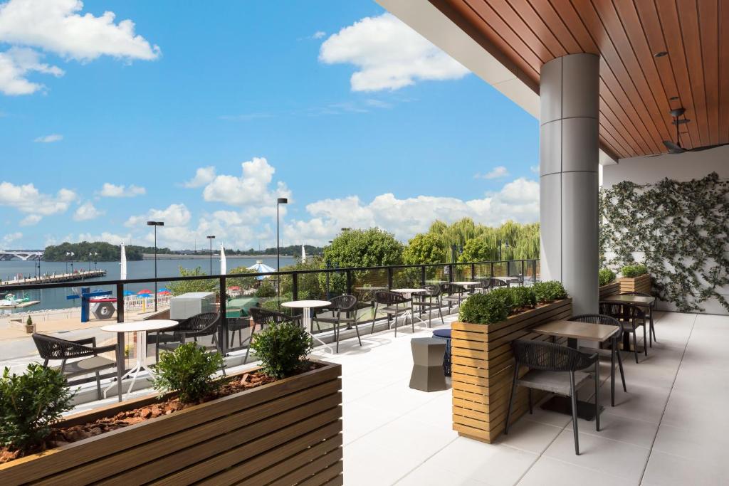 d'une terrasse avec tables et chaises et vue sur l'eau. dans l'établissement Hyatt Place National Harbor, à National Harbor