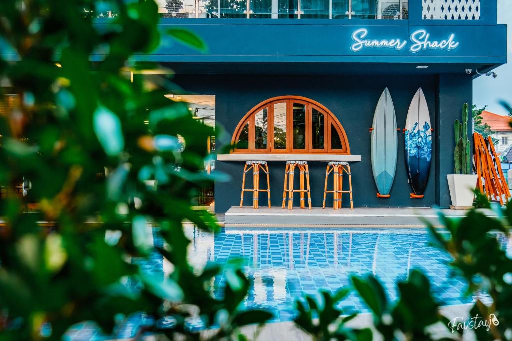 a house with surfboards on the side of a pool at So Boutique Jomtien Beach Pattaya in Jomtien Beach