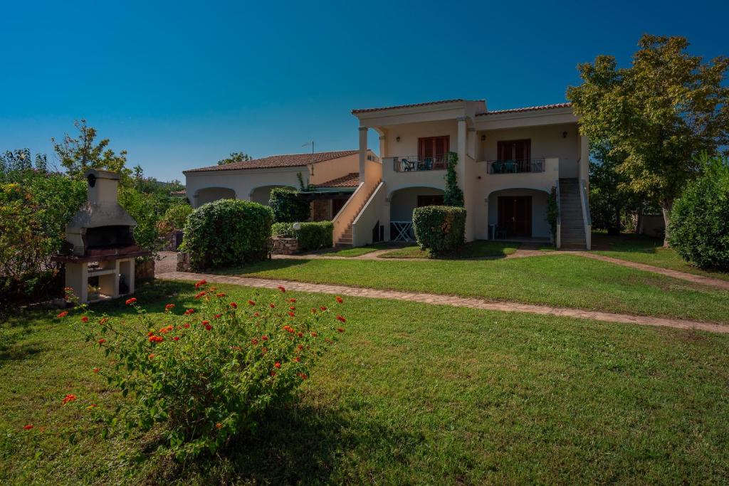 una grande casa con un cortile fiorito di Le Dimore di Budoni a Budoni