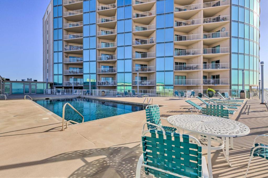 basen z krzesłami i stół przed budynkiem w obiekcie Sunny Beachfront Biloxi Condo with Resort Amenities! w mieście Biloxi